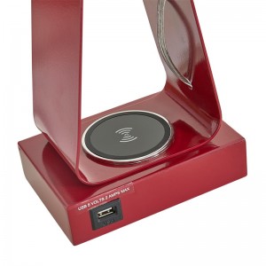 Pieni työpöytävalaisin, jossa on punainen viimeistely, USB -latausportti, langaton latausasema ja on/off -rokkarikytkin huoneessa